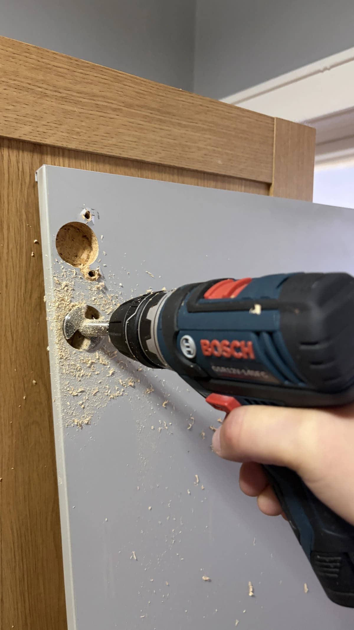 Drilling pilot holes with a cordless drill to install cabinet door hardware