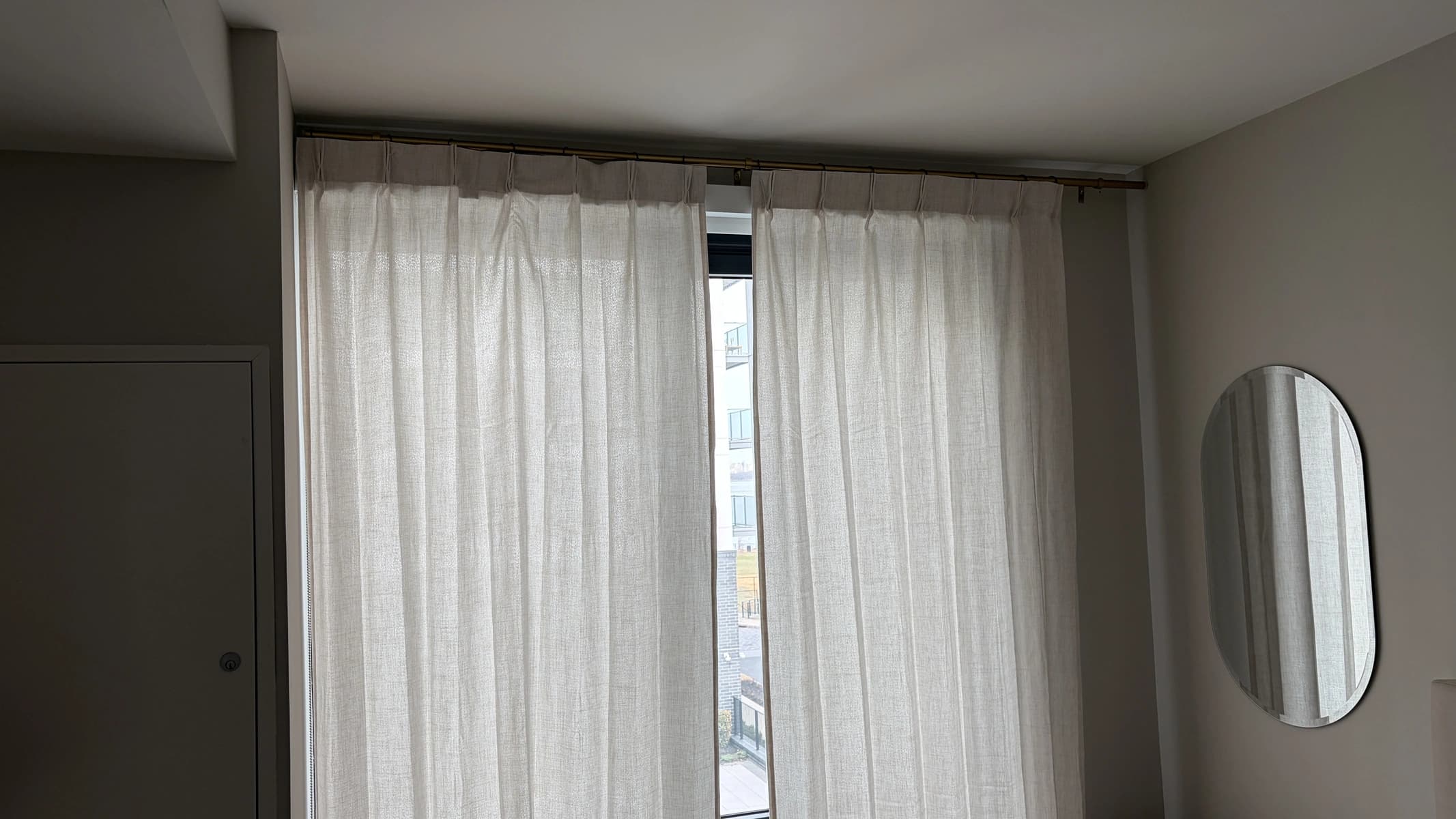 Sheer curtains hung on a ceiling-mounted track over a bedroom window