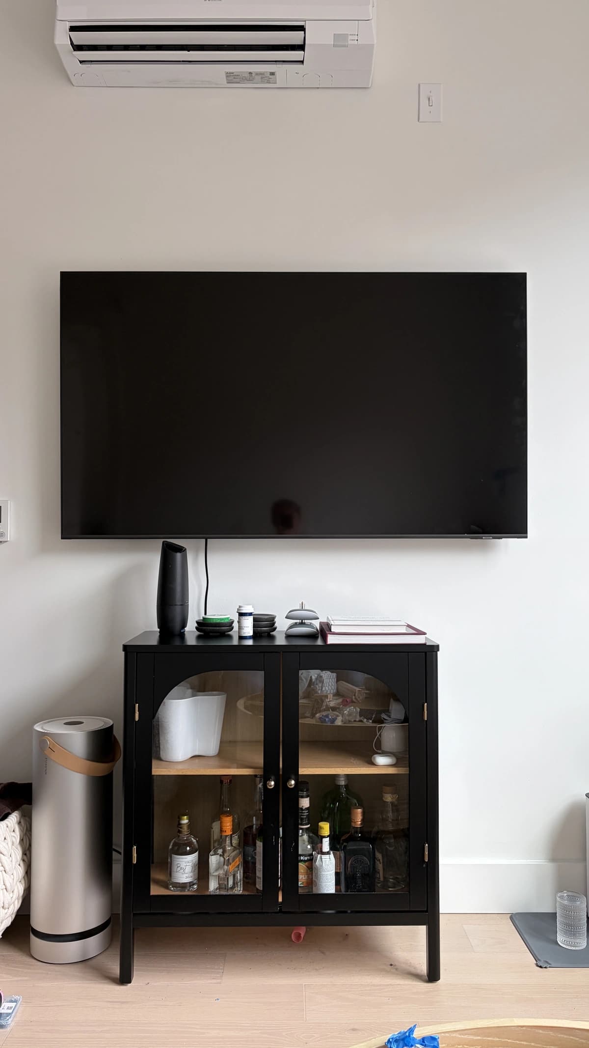 Flat-screen TV mounted on the wall above a media cabinet with cables concealed